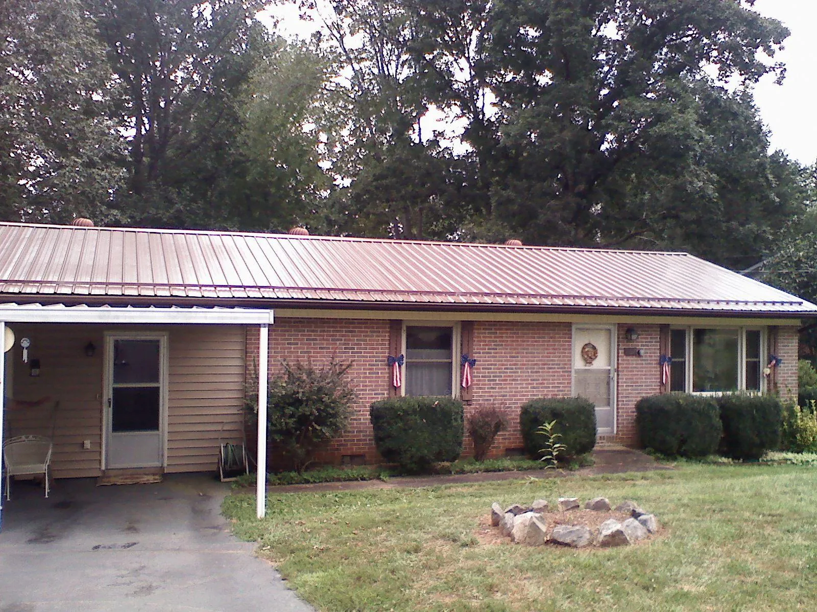 Bronze metal roof and carport on a brick ranch home — Roof Repair work by our crew in Duff
